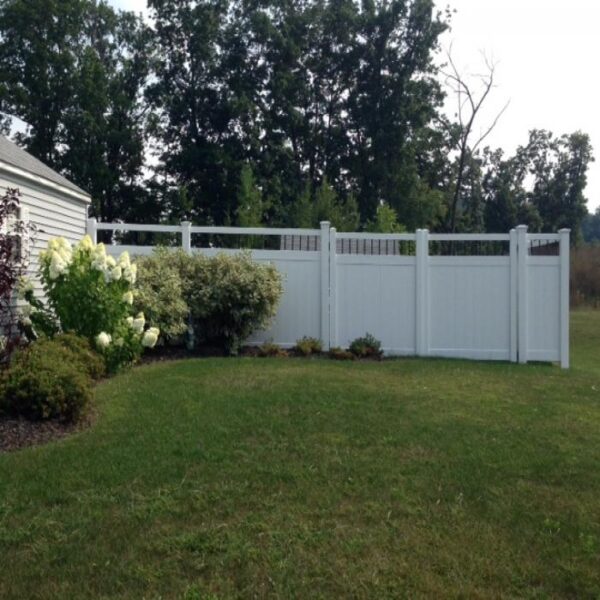 Townsend white vinyl privacy fence with flowering bushes