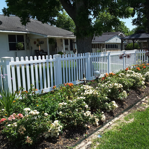 Burton white vinyl picket fence in behind flower garden