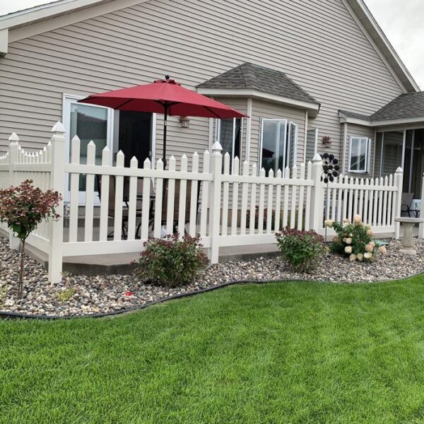 Grantham white vinyl picket fence on patio with red umbrella