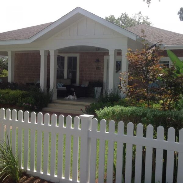 Sudbury white vinyl picket fence with dog on porch