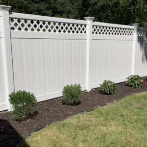 Winchester white vinyl privacy fence with small shrubs