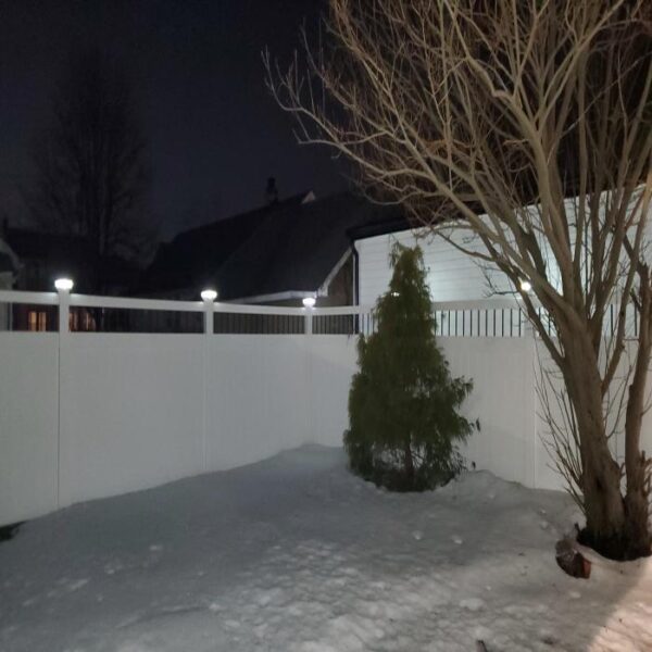 Florence white vinyl privacy fence in the snow